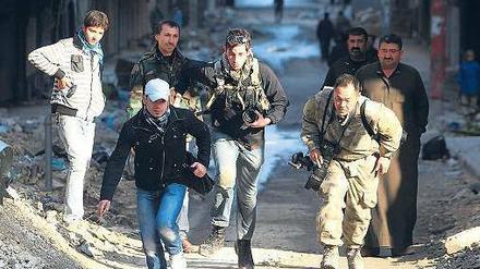 In den Straßen von Aleppo suchten diese Journalisten im Dezember vergangenen Jahres Deckung vor den Kämpfen zwischen Regierung und Rebellen. Seit Beginn des Bürgerkriegs wurden in Syrien mehr als 20 Medienmitarbeiter getötet. Foto: Muzaffar Salman/Reuters