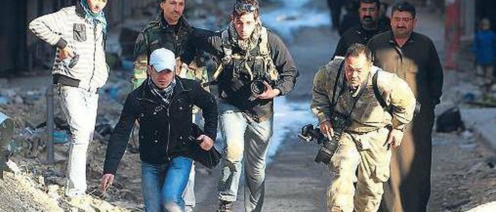 In den Straßen von Aleppo suchten diese Journalisten im Dezember vergangenen Jahres Deckung vor den Kämpfen zwischen Regierung und Rebellen. Seit Beginn des Bürgerkriegs wurden in Syrien mehr als 20 Medienmitarbeiter getötet. Foto: Muzaffar Salman/Reuters