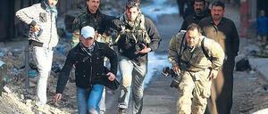 In den Straßen von Aleppo suchten diese Journalisten im Dezember vergangenen Jahres Deckung vor den Kämpfen zwischen Regierung und Rebellen. Seit Beginn des Bürgerkriegs wurden in Syrien mehr als 20 Medienmitarbeiter getötet. Foto: Muzaffar Salman/Reuters