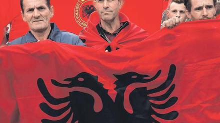 Kosovaren mit der albanischen Flagge im Hintergrund demonstrieren in Mitrovica gegen die Gespräche zwischen Serbien und dem Kosovo.