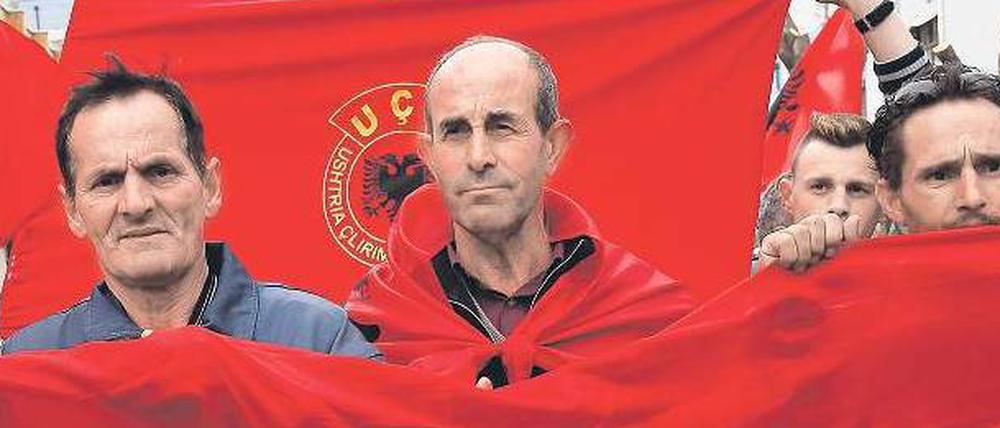 Kosovaren mit der albanischen Flagge im Hintergrund demonstrieren in Mitrovica gegen die Gespräche zwischen Serbien und dem Kosovo.
