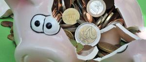 Zerbrochenes Sparschwein mit Euromünzen.