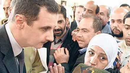 Der Herrscher und sein Volk: Assad unterhält sich mit einigen Syrern. Foto: dpa