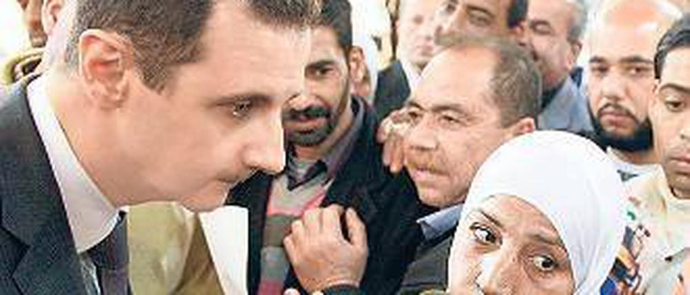 Der Herrscher und sein Volk: Assad unterhält sich mit einigen Syrern. Foto: dpa