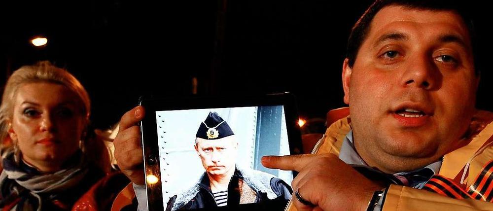 Demonstriert da der typische reiche Russe vor einer Bank in Zypern? Jedenfalls demonstriert er mit iPad und Putin. Aber wir halten uns an Martensteins Rat und wollen keine voreiligen Schlussfolgerungen ziehen.