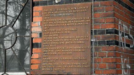 Die  Gedenktafel für das Alte Eierhäuschen hängt am Gebäude selbst, das zwischen Spreeufer und Plänterwald steht (Treptow).