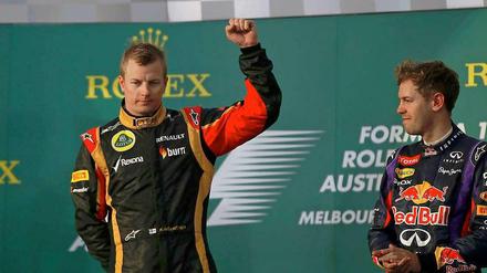 Mit kampfeslustigem Gruß: Kimi Räikkönen feiert seinen Auftakt-Sieg in Melbourne vor Fernando Alonso (links) und Sebastian Vettel.