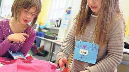 Den Übergang erleichtern – darum geht es beim alljährlichen Schnuppertag der Weddinger Erika-Mann-Grundschule. Alle künftigen Erstklässler werden eingeladen, damit sie sich frühzeitig auf ihre neue Umgebung einstellen können. Paten aus den oberen Klassen erleichtern ihnen das Eingewöhnen. Patin Frida (rechts) hilft der sechsjährigen Charleen beim Basteln und ist auch beim anschließenden Sprachtest dabei.