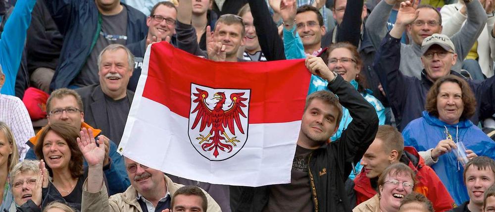 Kollektives Schmunzeln: Fans halten bei einem Konzert des Kabarettisten Rainald Grebe. Dem Bundesland Brandenburg hat er ein eigenes Stück gewidmet.