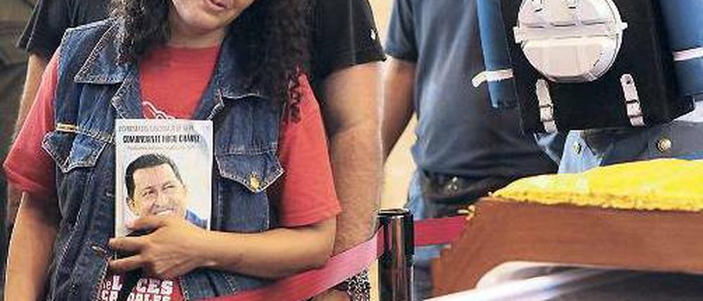 Am halb offenen Sarg. Eine Frau trauert in der Militärakademie der Hauptstadt Caracas um Venezuelas verstorbenen Staatschef Chávez. Am Sarg hielt eine vierköpfige Ehrengarde Wache. Foto: AFP