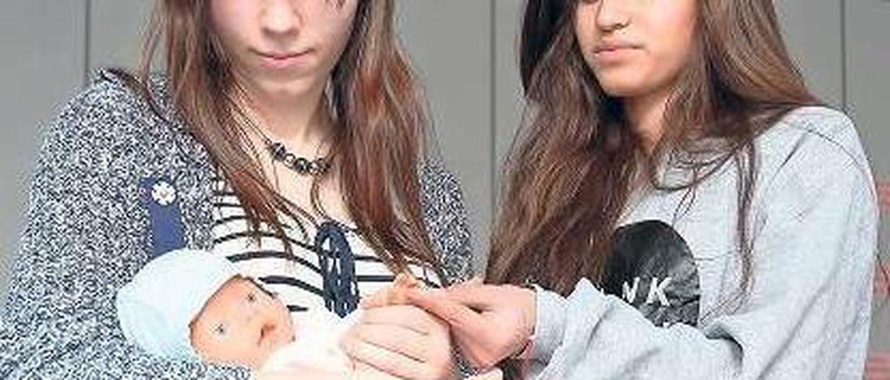 Puppe statt Kind. Maria Harke und Emily Candelario üben sich im Babysitterkurs des DRK. Foto: Björn Kietzmann