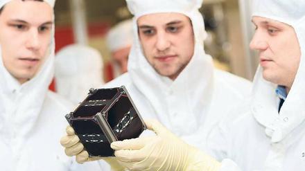 Gut geforscht. Doktoranden der Uni Würzburg mit ihrem Kleinsatelliten. Foto: dpa