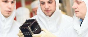 Gut geforscht. Doktoranden der Uni Würzburg mit ihrem Kleinsatelliten. Foto: dpa