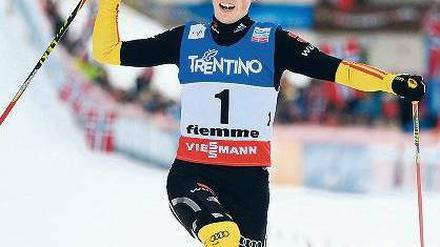 Knicks mit Fahne. Eric Frenzel passiert die Ziellinie und feiert sich selbst. Foto: dpa