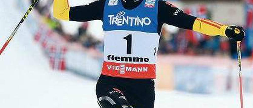 Knicks mit Fahne. Eric Frenzel passiert die Ziellinie und feiert sich selbst. Foto: dpa