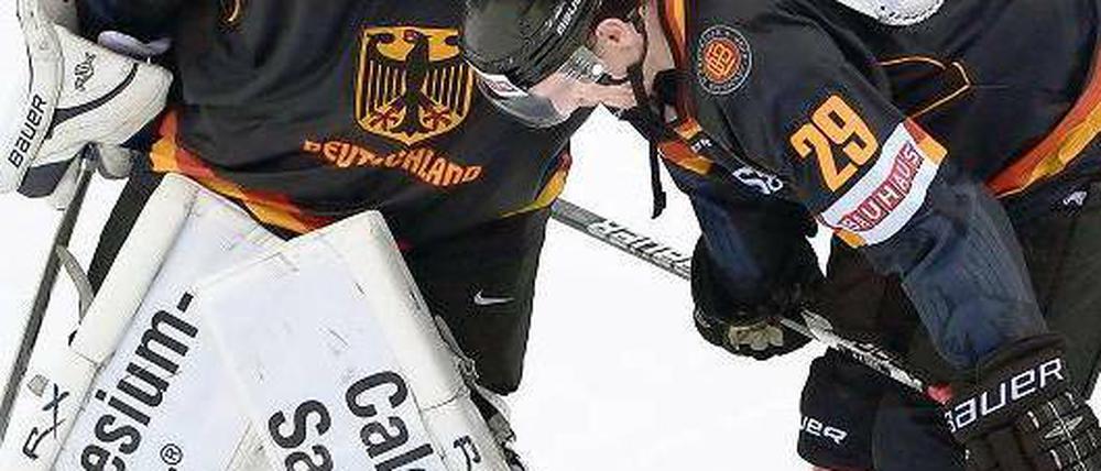 Wenn harte Männer weinen. Der deutsche Torhüter Rob Zepp von den Eisbären Berlin (links) muss seinen Stürmerkollegen Alexander Barta nach dem Debakel gegen die Österreicher trösten. Foto: dpa