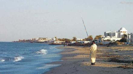 Wenn er könnte, würde sich dieser Mann am Strand der tunesischen Insel Djerba vermutlich gern ein paar Touristen angeln. 
