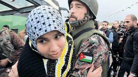 Dem Bürgerkrieg entkommen. Ein jordanischer Soldat hilft Syrern, denen bei Mafrak die Flucht über die Grenze zum Nachbarland gelungen ist. Foto: Mohammed Hamed/Reuters