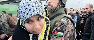 Dem Bürgerkrieg entkommen. Ein jordanischer Soldat hilft Syrern, denen bei Mafrak die Flucht über die Grenze zum Nachbarland gelungen ist. Foto: Mohammed Hamed/Reuters
