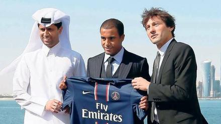 Die Drei von der Bankstelle. Der neue Präsident von Paris St. Germain Nasser al-Khelaifi (l.) und Sportdirektor Leonardo (r.) stellten am Neujahrstag vor der Skyline von Doha einen weiteren teuren Spieler vor: den Brasilianer Lucas. 