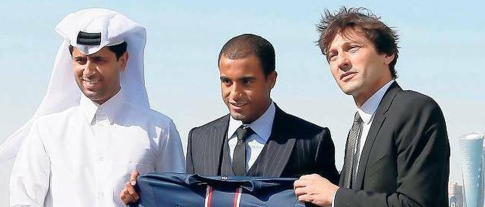 Die Drei von der Bankstelle. Der neue Präsident von Paris St. Germain Nasser al-Khelaifi (l.) und Sportdirektor Leonardo (r.) stellten am Neujahrstag vor der Skyline von Doha einen weiteren teuren Spieler vor: den Brasilianer Lucas. 