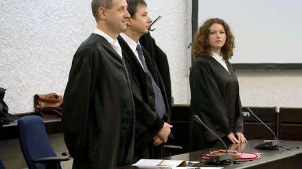 Die Anwälte des beklagten Vaters des Amokläufers von Winnenden, Hubert Gorka (l-r), Hans Steffan und Elisabeth Unger-Schnell stehen am in einem Gerichtssaal des Landgerichts in Stuttgart (Baden-Württemberg) vor der Urteilsverkündung im zweiten Prozess gegen den Vater des Amokläufers von Winnenden und Wendlingen an einer Bank.