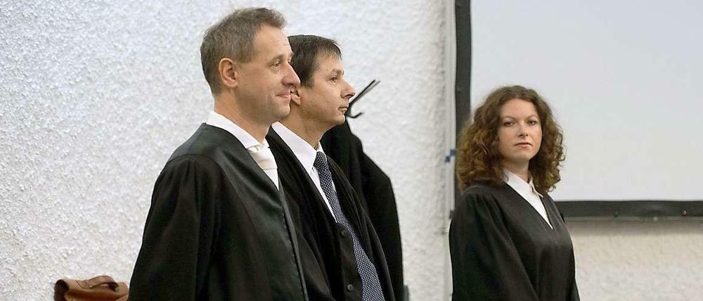 Die Anwälte des beklagten Vaters des Amokläufers von Winnenden, Hubert Gorka (l-r), Hans Steffan und Elisabeth Unger-Schnell stehen am in einem Gerichtssaal des Landgerichts in Stuttgart (Baden-Württemberg) vor der Urteilsverkündung im zweiten Prozess gegen den Vater des Amokläufers von Winnenden und Wendlingen an einer Bank.