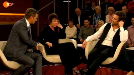 Markus Lanz beruhigt Schauspielerin Katrin Sass, die schimpft auf Dschungelcamper Peer Kusmagk (re.).