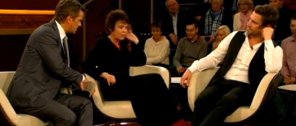Markus Lanz beruhigt Schauspielerin Katrin Sass, die schimpft auf Dschungelcamper Peer Kusmagk (re.).