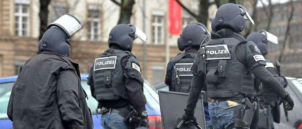 Beamte des SEK verlassen am Ende des Einsatzes das Unigelände.