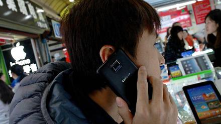Immer schneller prasseln neue Geräte auf den Markt. Dieser Mann testet ein Coolpad 7290 auf einem Markt in Shanghai.