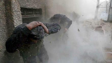 Rebellen der Freien Syrischen Armee (FSA) suchen Schutz während einer Explosion im Damaszener Ostviertel Ain Tarma.
