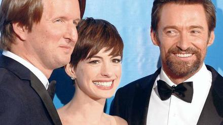Das Lächeln der Stars. Regisseur Tom Hooper bringt bringt neben seinem Film "Les Misérables" auch die Darsteller Anne Hathaway und den bärtigen Hugh Jackman mit. 