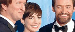 Das Lächeln der Stars. Regisseur Tom Hooper bringt bringt neben seinem Film "Les Misérables" auch die Darsteller Anne Hathaway und den bärtigen Hugh Jackman mit. 