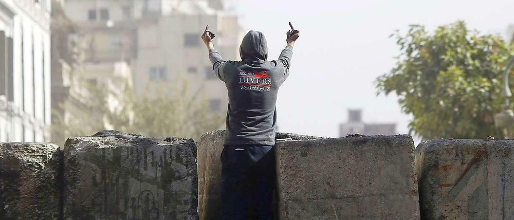 Ein junger Demonstrant klettert in Nähe des Kairoer Tahrirplatzes auf ein Bollwerk: Zum zweiten Jahrestag der Revolution kommt es zu Ausschreitungen gegen die Mursi-Regierung