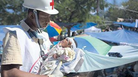 Der Helfer Jean Zacharie hat 2010 in Haiti ein Baby aus den Trümmern geborgen. Die Mutter starb bei dem Beben. Foto: Talia Frenkel/AFP