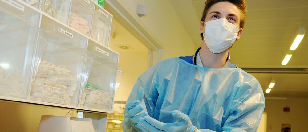 Hygiene-Routine. Pflegeschüler Christoph Groß bereitet sich vor, ein Krankenzimmer der Intensivstation 144i an der Charité zu betreten.