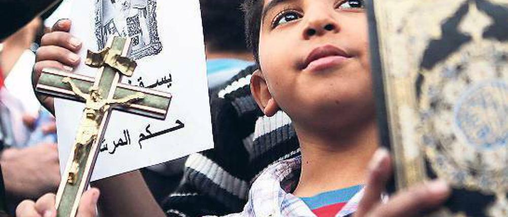 Friedlicher Widerstand. Zwei Jungen halten bei einem Protestmarsch zum Präsidentenpalast von Mohammed Mursi in Kairo ein Kruzifix und eine Kopie des Koran in der Hand.Foto: dpa