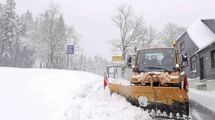Ein Räumfahrzeug schiebt im Thüringer Wald Schnee von einer Strasse.