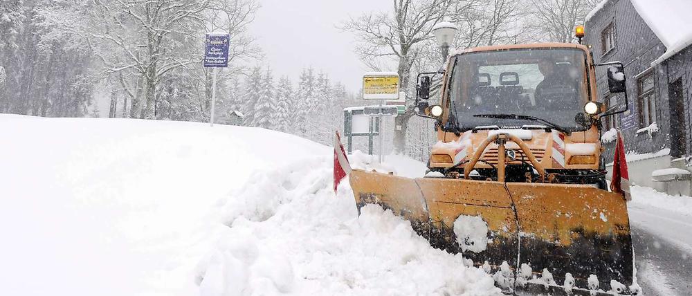 Ein Räumfahrzeug schiebt im Thüringer Wald Schnee von einer Strasse.