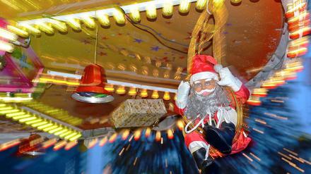 Ein Plastiknikolaus fährt auf dem Berliner Weihnachtsmarkt Karussell.