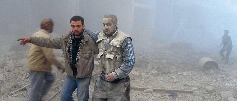 Bild aus einem Krieg. Rebellenkämpfer nach einem Luftangriff in Akraba, einer Vorstadt von Damaskus. 