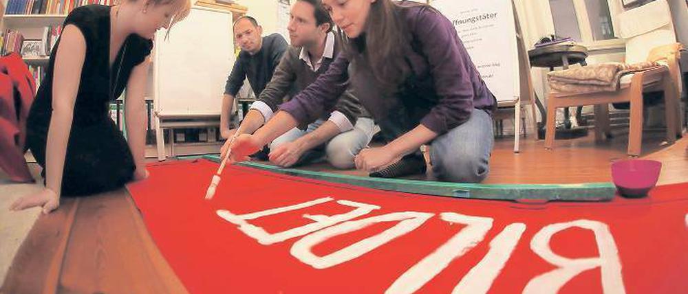 Politische Malstunde. Die Initiatoren der Gruppe „Was bildet ihr uns ein“ bereiten ihr Demo-Transparent vor. Susanne Julia Czaja, Ali Hotait, Rainald Manthe, Bettina Malter haben rund 2500 E-Mails an Abgeordnete des Bundestages, der Landtage und des EU-Parlaments geschickt, um für ihre Forderungen zu werben. Foto: Björn Kietzmann