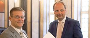 Der neue Opferschutzbeauftragte Roland Weber (l.) bekommt von Justizsenator Thomas Heilmann die Ernennungsurkunde überreicht.