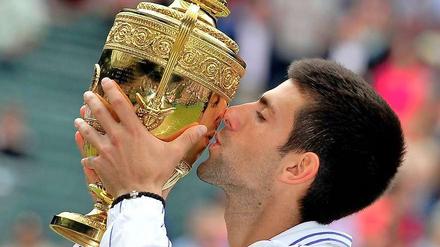Novak Djokovic küsst erstmal den Siegerpokal von Wimbledon.