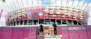 Noch zu tun. Arbeiter befestigen einen Sichtschutz am Nationalstadion in Warschau, in dem am Freitag das EM-Eröffnungsspiel Polen gegen Griechenland ausgetragen wird.