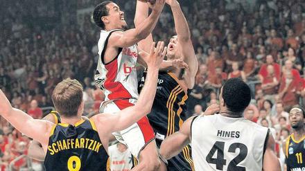 Es geht hoch her. Bambergs Brian Roberts (Mitte) wird im ersten Finale von Alba Berlins Yassin Idbihi attackiert.