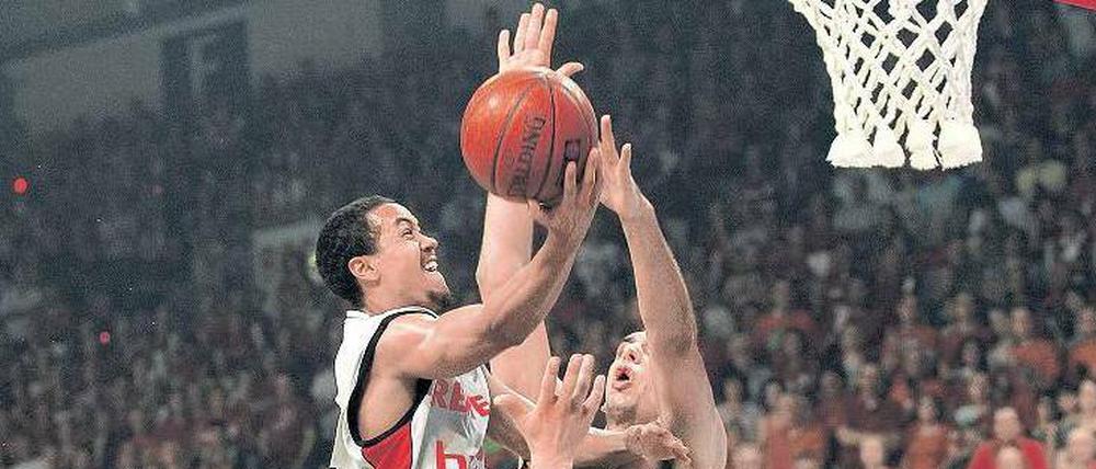 Es geht hoch her. Bambergs Brian Roberts (Mitte) wird im ersten Finale von Alba Berlins Yassin Idbihi attackiert. 