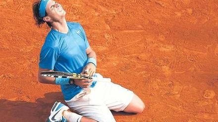 Genug gequält. Rafael Nadal ließ sich nach seinem Sieg über Roger Federer glücklich in die rote Asche von Paris sinken. Der Spanier hatte in den ersten Runden einige Probleme gehabt und selbst nicht an den erneuten Titelgewinn geglaubt. Foto: Reuters