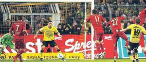 Mit dem Rücken zum Tor. Robert Lewandowski (Mitte) braucht gar nicht hinzusehen, bevor er mit der Hacke das Siegtor für Borussia Dortmund erzielt. Foto: Reuters